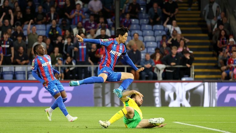 Crystal Palace's Daichi Kamada, center, scores their side's first goal...