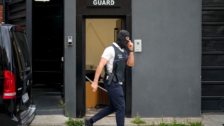 A police officer exits the residence of social media personality...