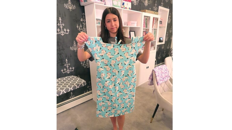 Giuliana Demma holds a pediatric hospital gown she had just...