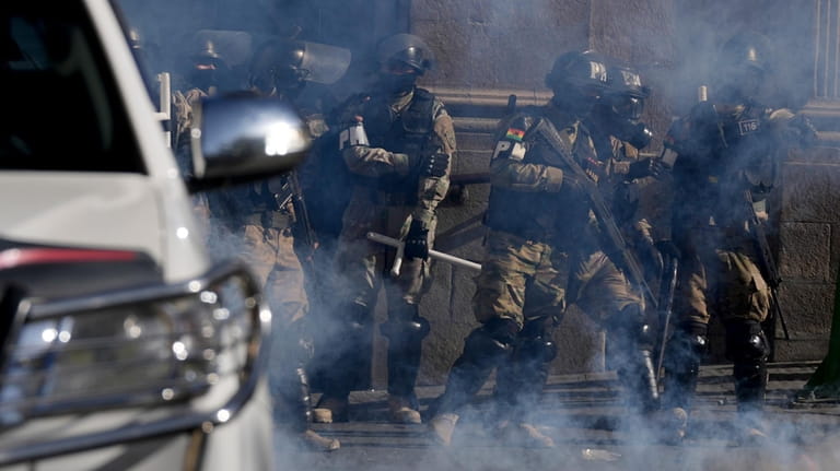 Military Police stand amid tear gas they fired outside the...