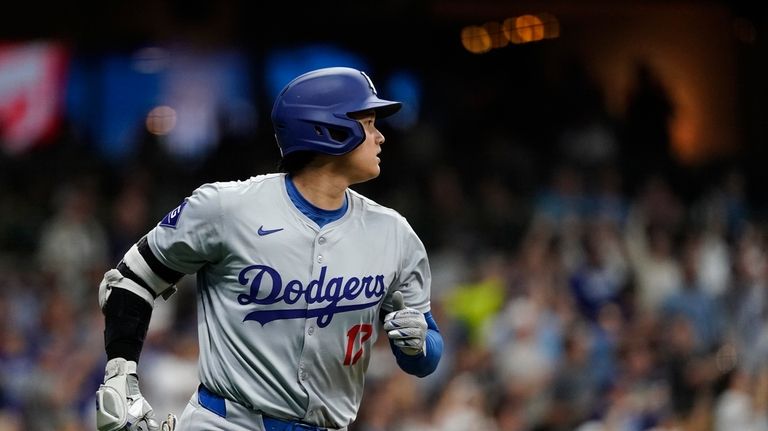 Los Angeles Dodgers' Shohei Ohtani watches the ball after hitting...