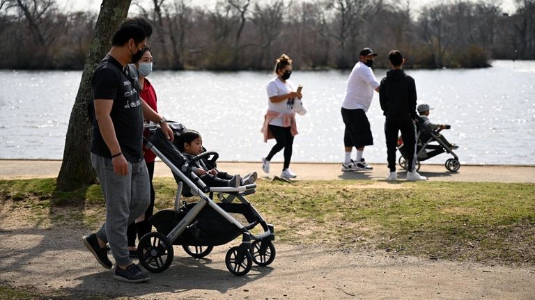 Dylan and Cherlyn Chung, of Islip, strolled with their son...