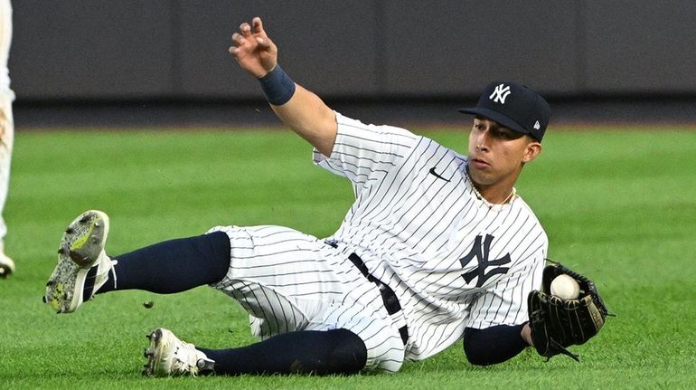 Yankees rightfielder Oswaldo Cabrera slides to make the catch against...