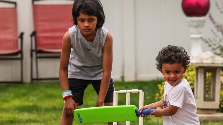 Vijay Raghunath, 3, plays cricket with his brother, Veer, 9,...