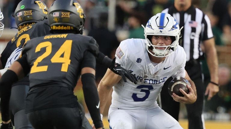 Air Force quarterback John Busha looks for an opening in...