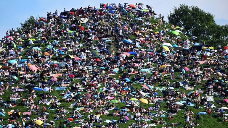 Fans sit on the Olympiaberg and wait in the sunshine...