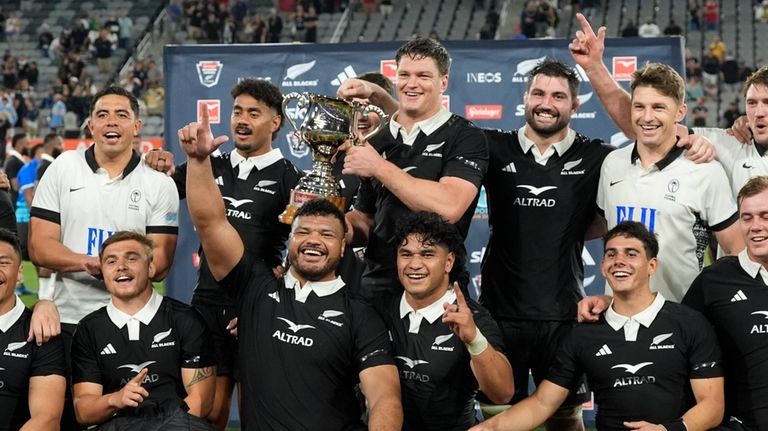 New Zealand captain Scott Barrett, above center, holds the trophy...