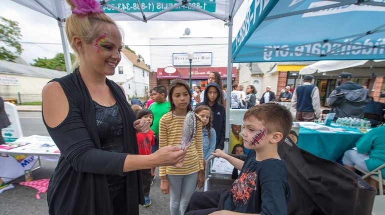 Face painter Tara Scarfo shows Nico Stasio of Central Islip, the artwork...