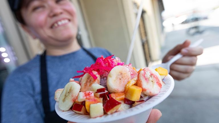 Evelyn Enamorado with a Salvadorean snow cone covered with bananas,...