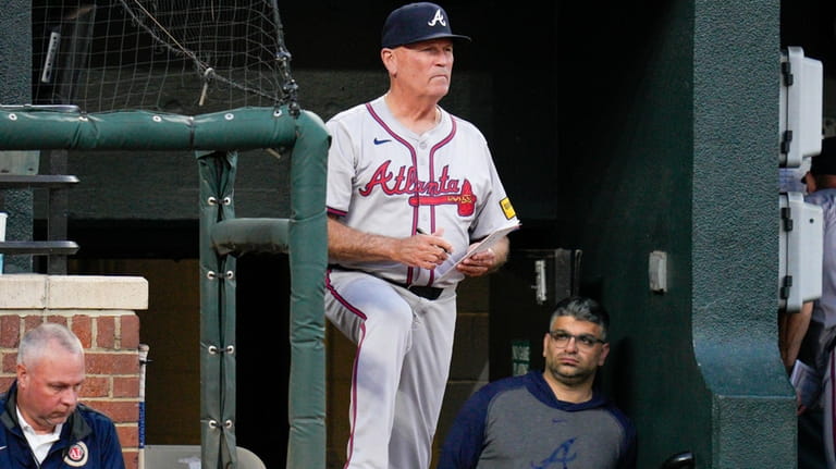 Atlanta Braves manager Brian Snitker looks on from the dugout...