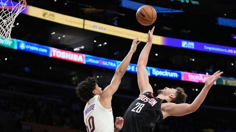 Houston Rockets center Alperen Sengun, right, shoots as Los Angeles...