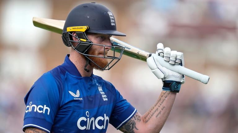 England's Ben Stokes holds up his bat to applause as...