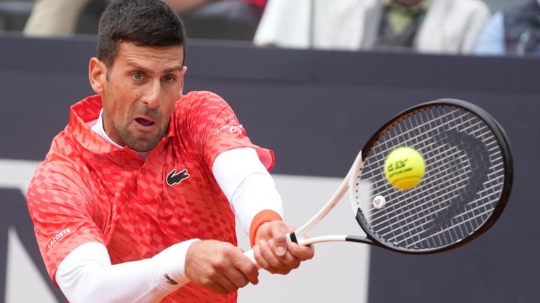 Serbia's Novak Djokovic returns the ball to Denmark's Holger Rune...