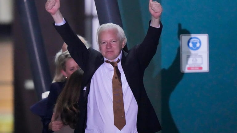 WikiLeaks founder Julian Assange gestures after landing at RAAF air...