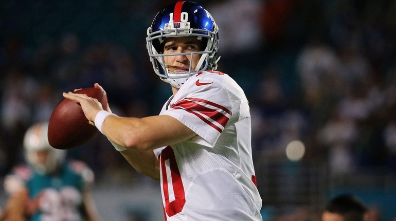 Eli Manning #10 of the New York Giants warms up...