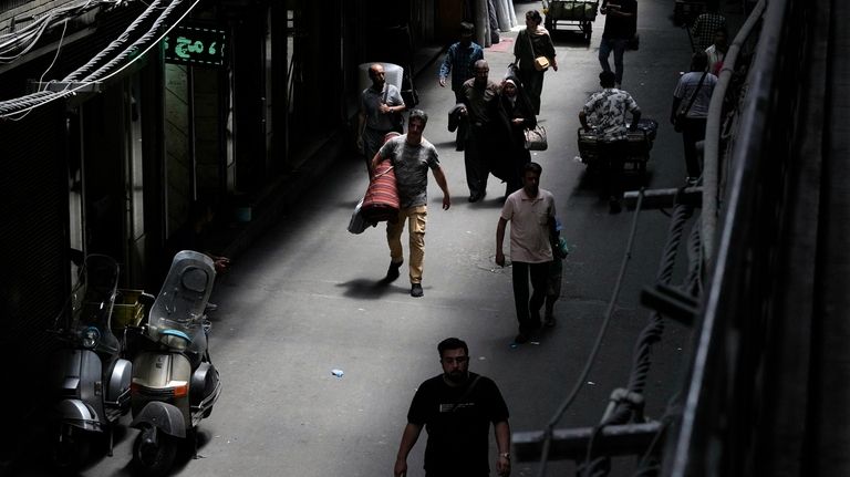 People walk through the old main bazaar of Tehran, Iran,...