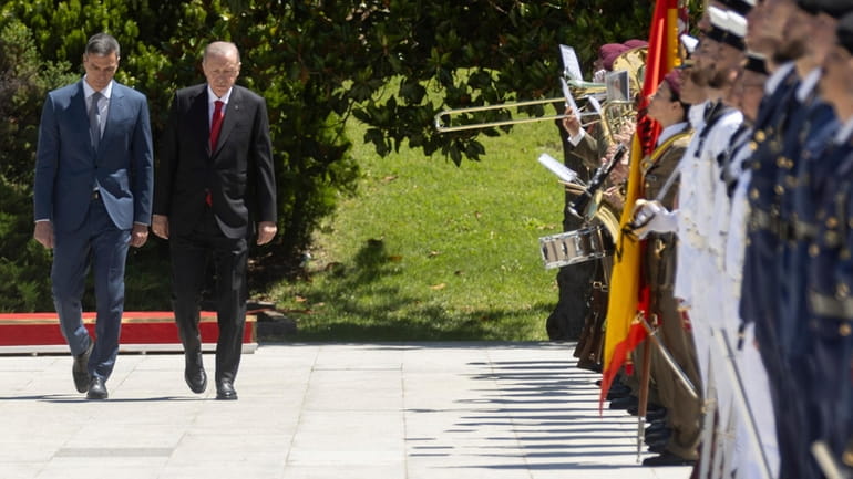 Spanish Prime Minister Pedro Sanchez, left, walks with Turkish President...