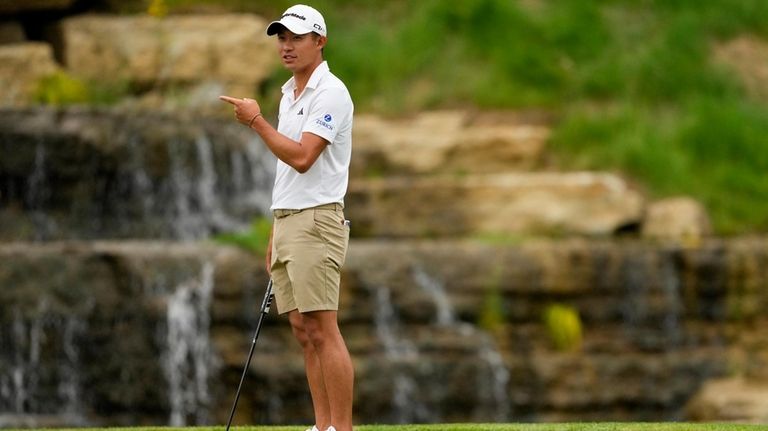 Collin Morikawa lines up a putt on the 13th hole...