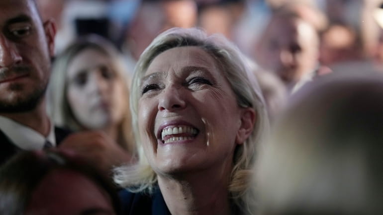 French far right leader Marine Le Pen reacts as she...