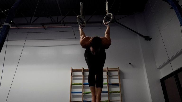 Angela Fuller, 44, works out on the rings as she...