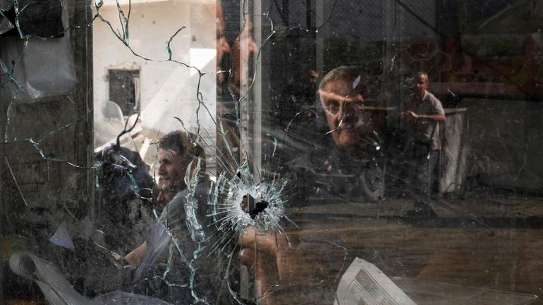 A bullet hole is seen in a shop window following...