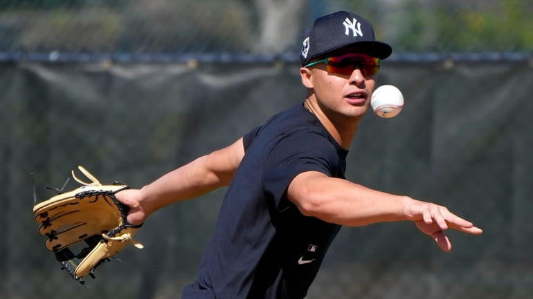 Yankees shortstop Anthony Volpe tosses the ball to second base...