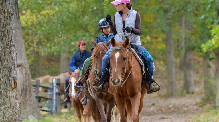 Equestrian volunteer Renalda Franks leads Walter and Linda Sabolboro and...