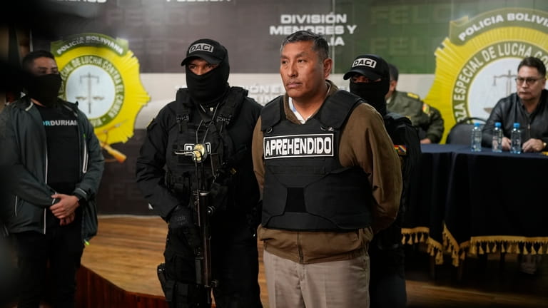 Police hold the detained Juan Arnez Salvador, ex-commander general of...