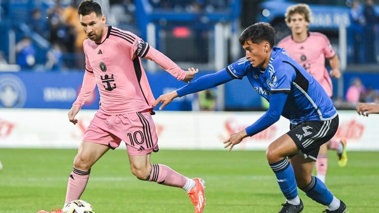 Inter Miami's Lionel Messi, left, gets by CF Montreal's Fernando...