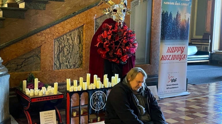 A man prays in Latin in front of a display...