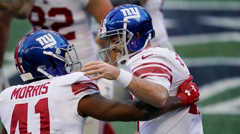 Giants quarterback Colt McCoy, right, greets running back Alfred Morris...