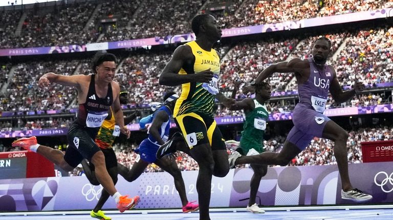 Noah Lyles, right, of the United States, looks at Oblique...