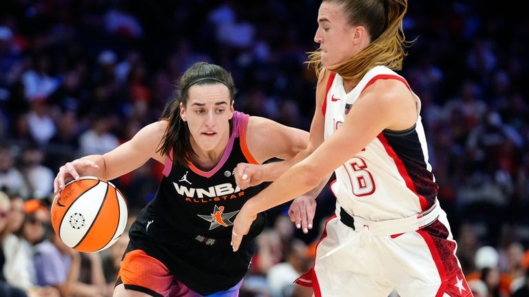 Caitlin Clark, left, of Team WNBA, dribbles against Sabrina Ionescu...