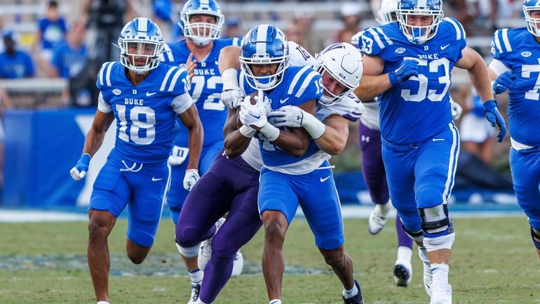 Duke's Travis Bates (19) is tackled by Northwestern's Aidan Hubbard...