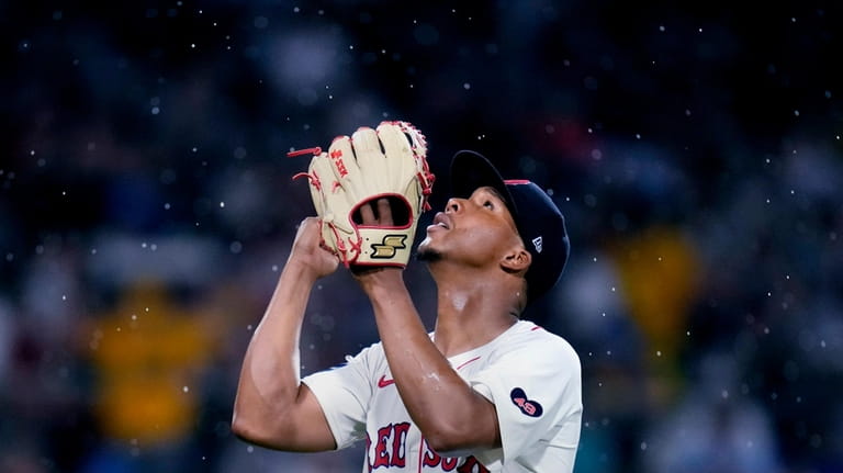 Boston Red Sox pitcher Brayan Bello celebrates as rain falls...