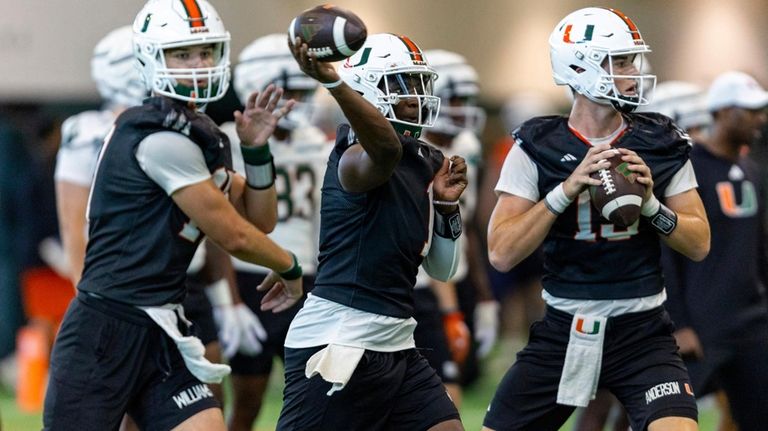 Miami Hurricanes quarterbacks Cam Ward (1), center, Emory Williams (17),...