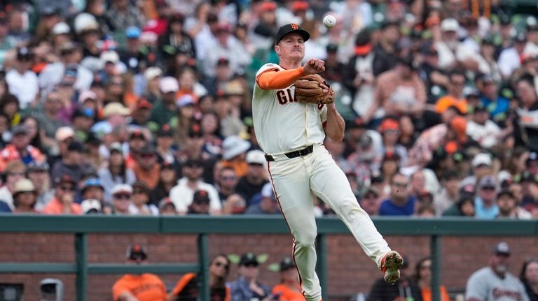 San Francisco Giants third baseman Matt Chapman throws to first...