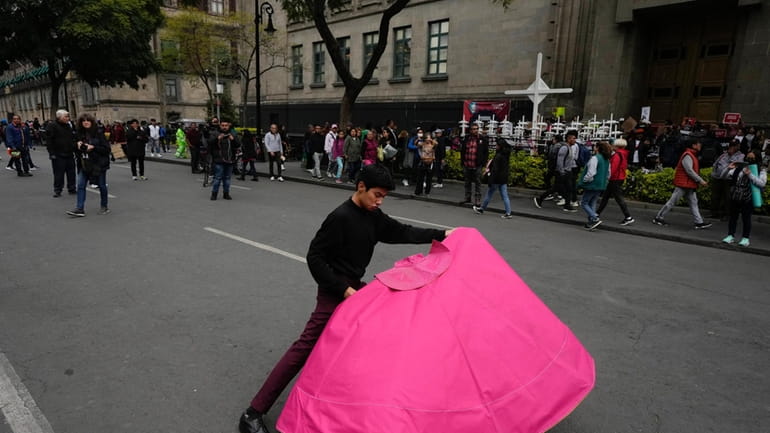 Juan Pablo Vargas makes matador cape movements during a demonstration...