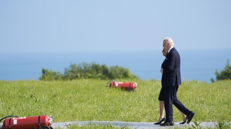 President Joe Biden and first lady Jill Biden walk a...