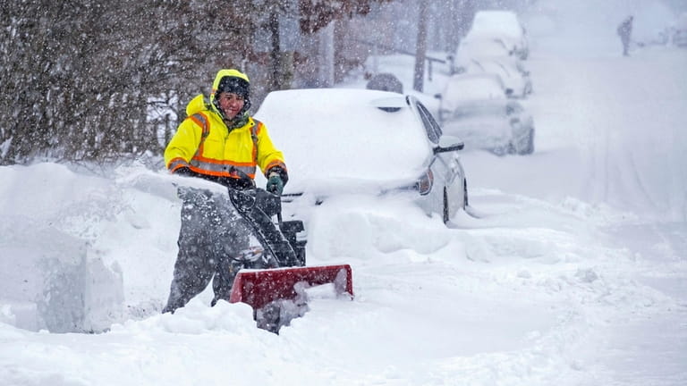Dolores Garcia clears snow at his home in Huntington Station on Jan....
