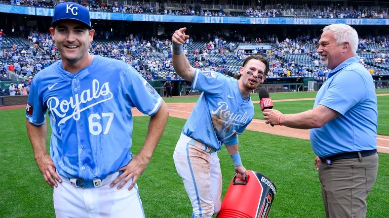 Kansas City Royals' Bobby Witt Jr., center, leads the crowd...