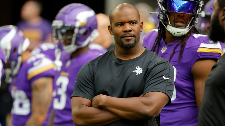 Vikings defensive coordinator Brian Flores watches his players prior to...