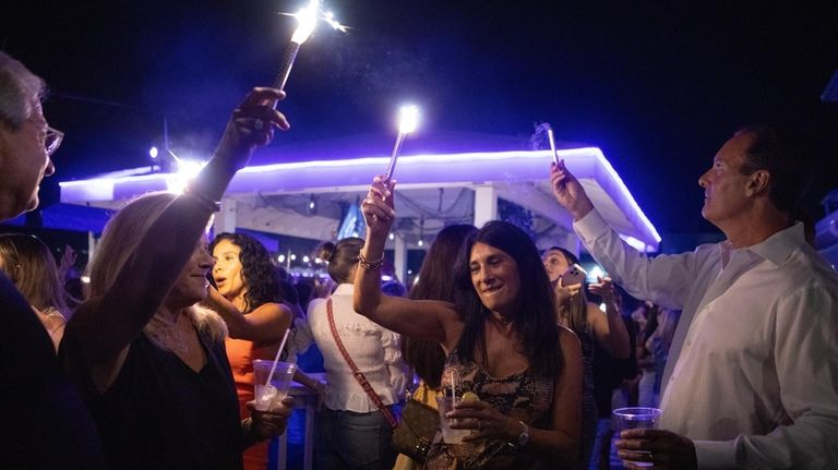 Patrons dance with sparklers at The Cove in Glen Cove.