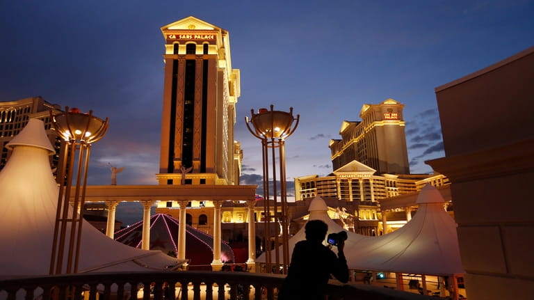 A man takes pictures of Caesars Palace hotel and casino...
