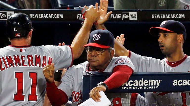 Washington Nationals' Ryan Zimmerman (11) is greeted at the dugout...