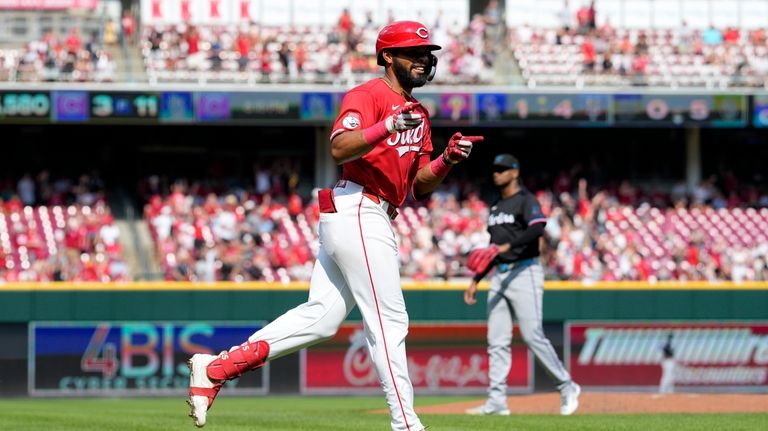 Cincinnati Reds' Rece Hinds, foreground, gestures to the dugout as...