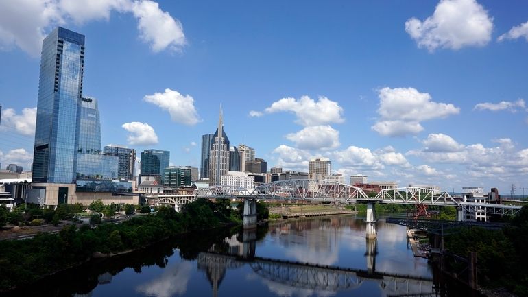 The Nashville, Tenn., skyline is reflected in the Cumberland River...