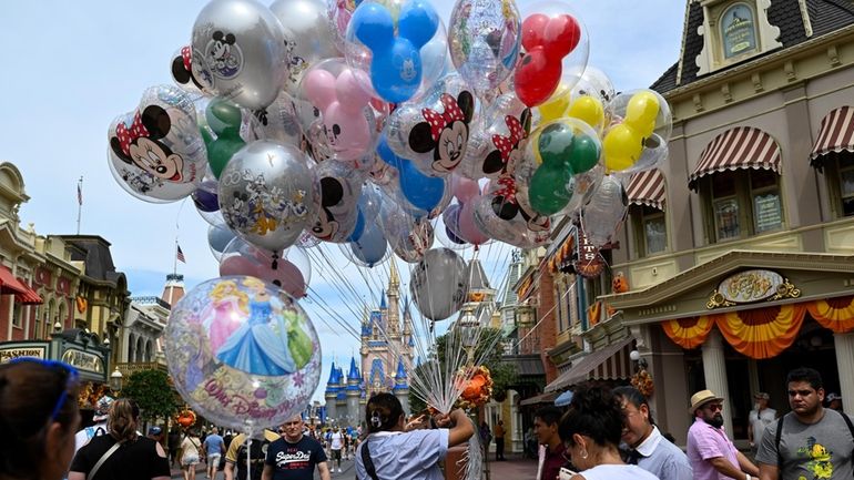 A vendor sells balloons in Walt Disney World's Magic Kingdom. 