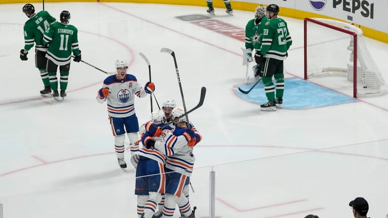 Edmonton Oilers players celebrate a game-winning goal by center Connor...