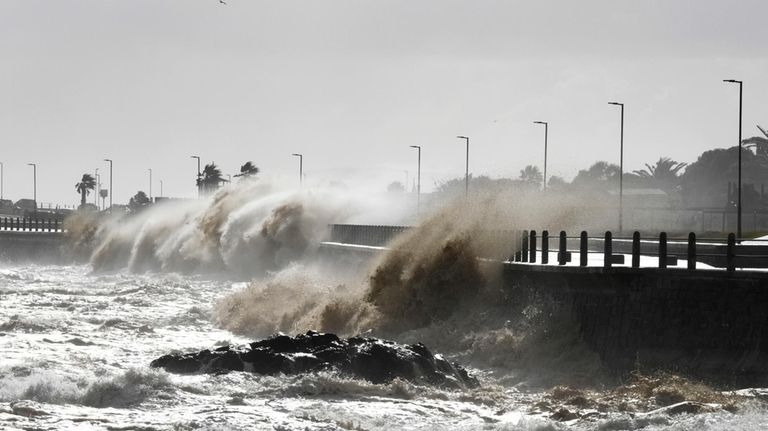 Waves break over Sea Point's promenade in Cape Town, South...